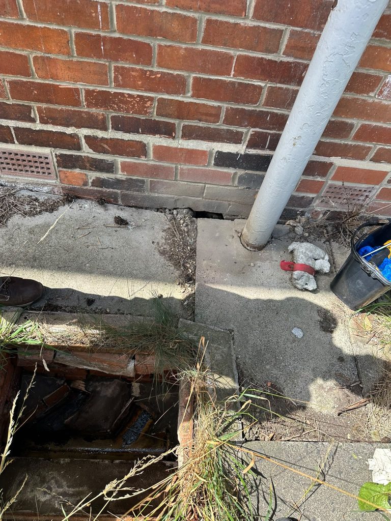 und-level void beneath external brickwork providing potential rat access into a residential block of flats in Gateshead.