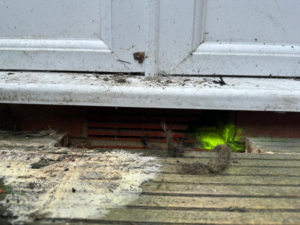 Rat-damaged PVC air brick concealed behind timber decking at a residential property in Blyth (NE24).